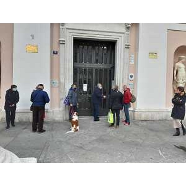 Persone in attesa di accedere allo sportello per i ristori Coop all'esterno della sede camerale di piazza della Borsa a Trieste - Persone in attesa di accedere allo sportello per i ristori Coop all'esterno della sede camerale di piazza della Borsa a Trieste