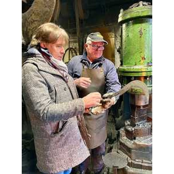 L'assessore Sergio Emidio Bini ammira un attrezzo appena forgiata dal fabbro Giorgio Beltrame nella sua fucina in attività dal 1454 - L'assessore Sergio Emidio Bini ammira un attrezzo appena forgiata dal fabbro Giorgio Beltrame nella sua fucina in attività dal 1454