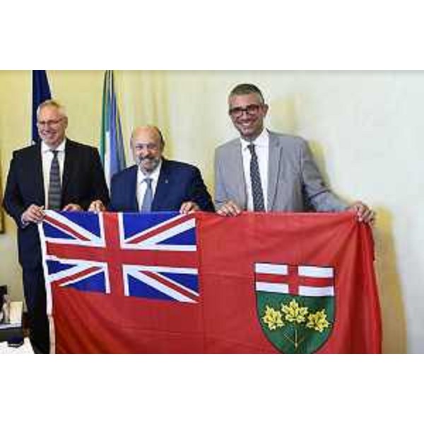 L'assessore Roberti, il ministro Tibollo e il presidente del Consiglio regionale Bordin con la bandiera dell'Ontario. - L'assessore Roberti, il ministro Tibollo e il presidente del Consiglio regionale Bordin con la bandiera dell'Ontario.