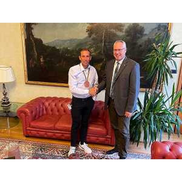 Stretta di mano tra il presidente del Cr Fvg, Mauro Bordin, e l'atleta azzurro Andrea Tarlao - Stretta di mano tra il presidente del Cr Fvg, Mauro Bordin, e l'atleta azzurro Andrea Tarlao